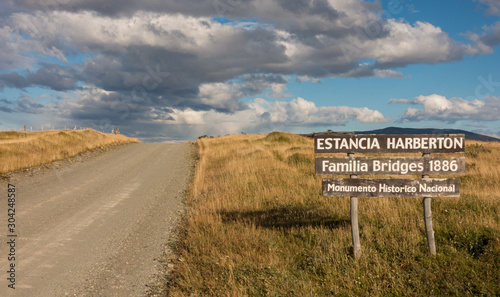 Road sign (eng. Estancia Harberton, Bridges Family 1886, National Historic Monument) near entrance to Estancia Harberton, Patagonia, Argentina photo