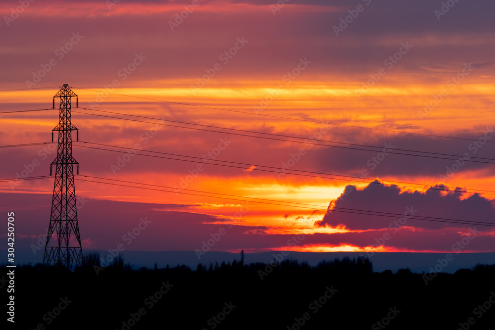 Fiery Red Sunset with Electricity Pylon Silhouette Fiery Red Sunset with Electricity Pylon Silhouette