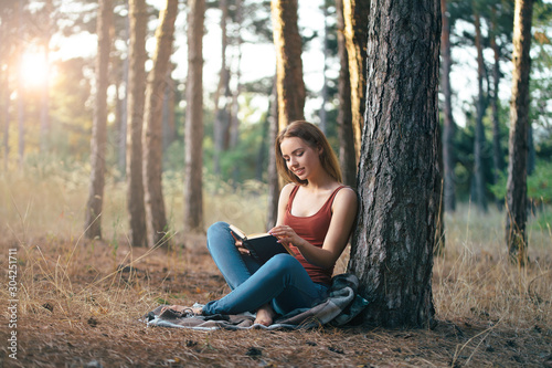 woman read in nature under tree