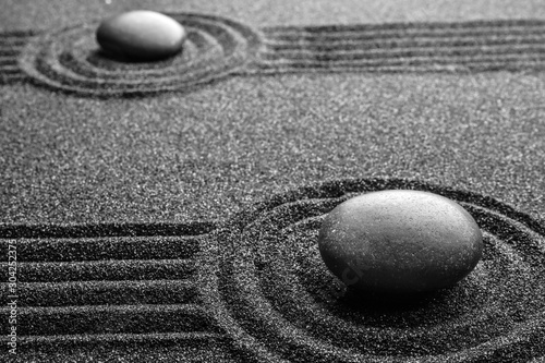 Photography Black sand with stones and beautiful pattern. Zen concept