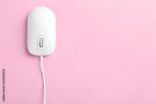 Modern wired optical mouse on pink background, top view. Space for text