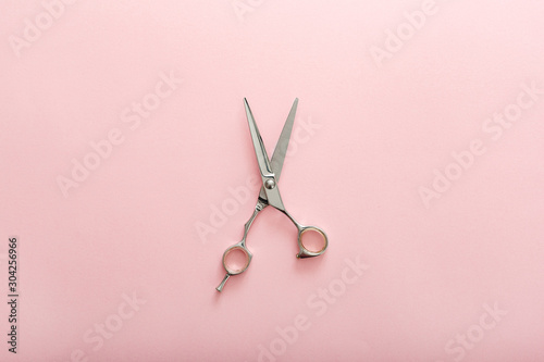 Hairdresser tools. Hairdresser scissors on pink color background with copy space for text. Hairdresser service. Beauty salon service photo