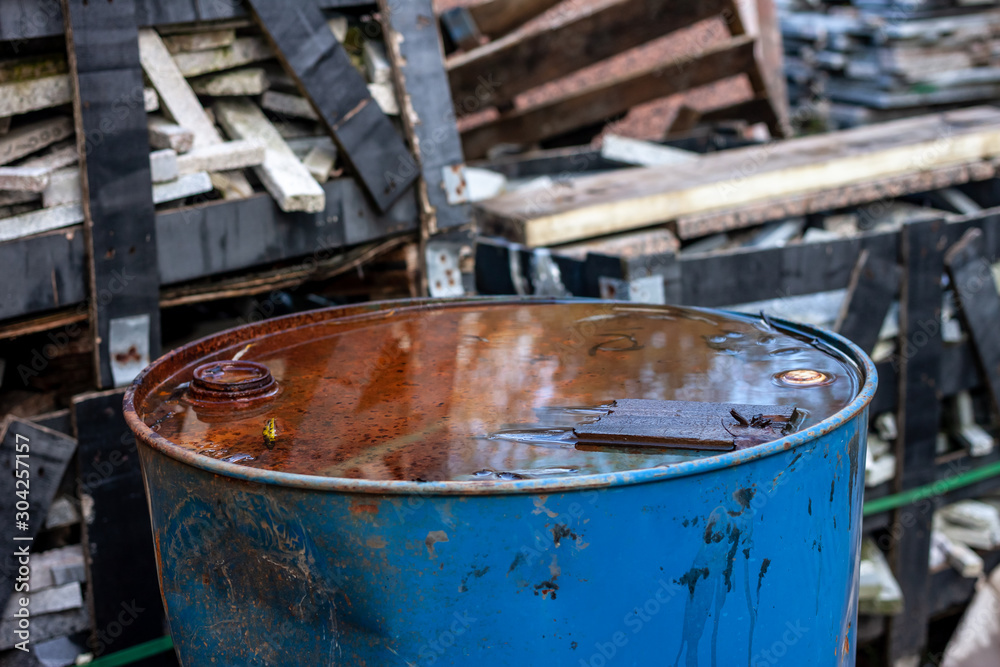 old iron rusty barrel among trash on dump