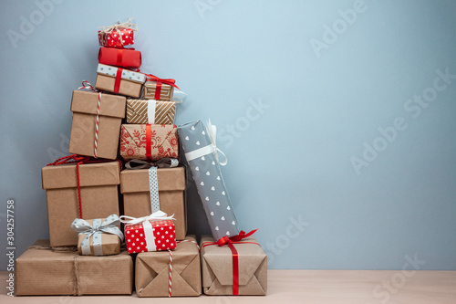 pile of wrapped christmas gifts on blue background