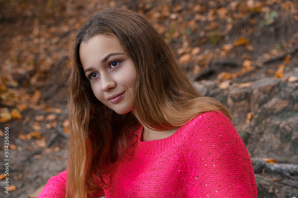 Portrait of beautiful teenage girl on the walk in fall park