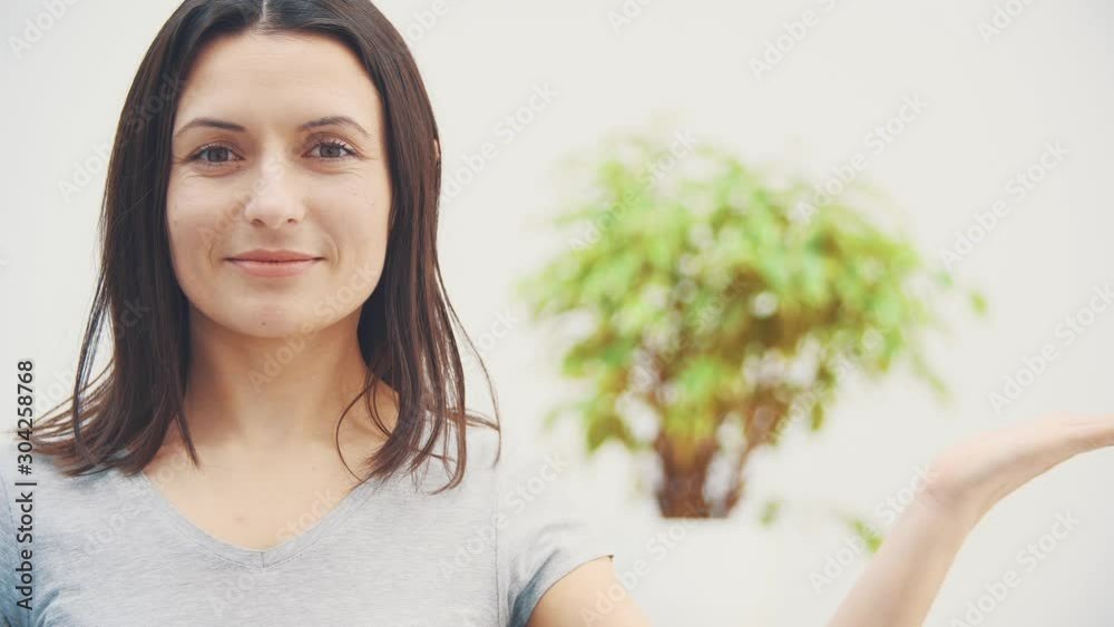 Beautiful woman with shining smile, looking at the camera, giving thumb up, holding open palm for text or product. Beautiful woman with shining smile, looking at the camera, giving thumb up, holding open palm for text or product.
