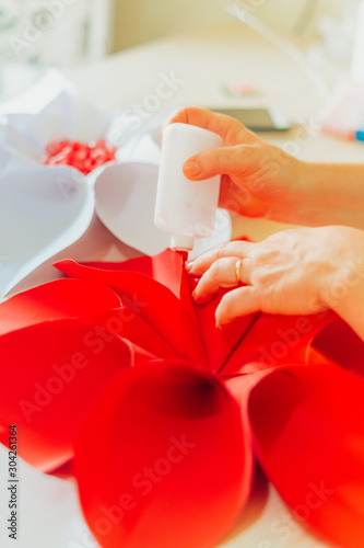  lady's hand sticking glue on paper a large flower-shaped origami for decoration
