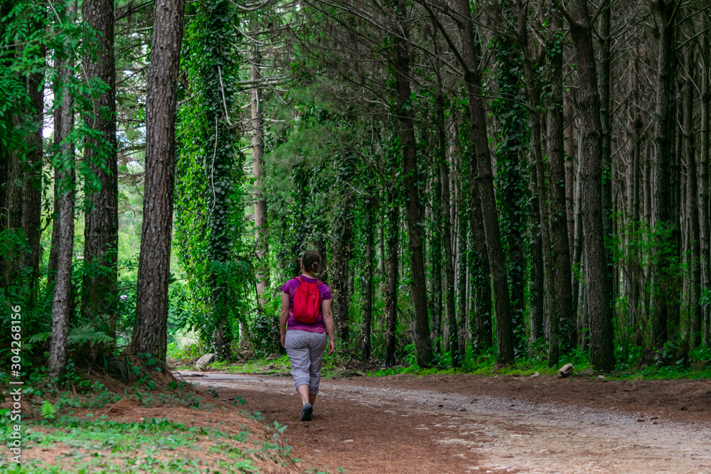 Mature woman walking in a road with trees near Curitiba, Parana, Brazil