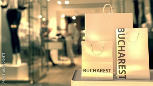 Wallpaper Mural Paper shopping bags with Bucharest caption against blurred store entrance. Retail in Romania related conceptual 3D animation Torontodigital.ca