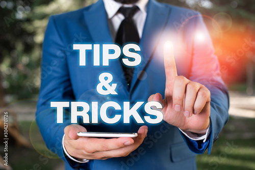 Conceptual hand writing showing Tips And Tricks. Concept meaning Steps Lifehacks Handy advice Recommendations Skills Businessman with pointing finger in front of him photo