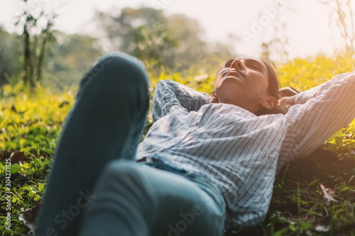 caucasian pretty young woman take rest on green lawn in park