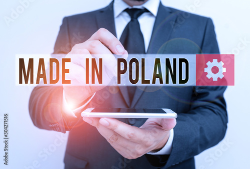 Text sign showing Made In Poland. Business photo text A product or something that is analysisufactured in Poland Male human wear formal work suit hold smart hi tech smartphone use one hand photo