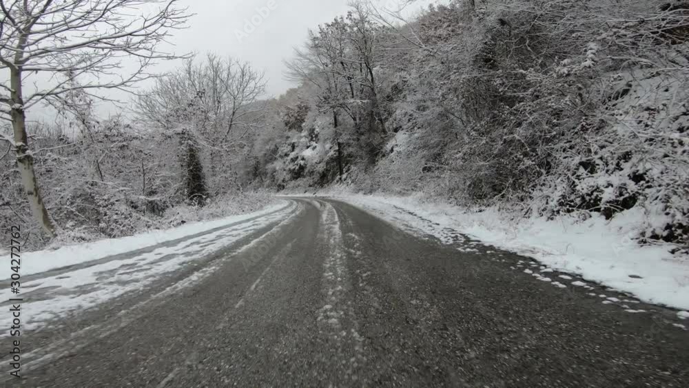 Driving a car on dangerous frozen and icy road on a mountain pass Driving a car on dangerous frozen and icy road on a mountain pass