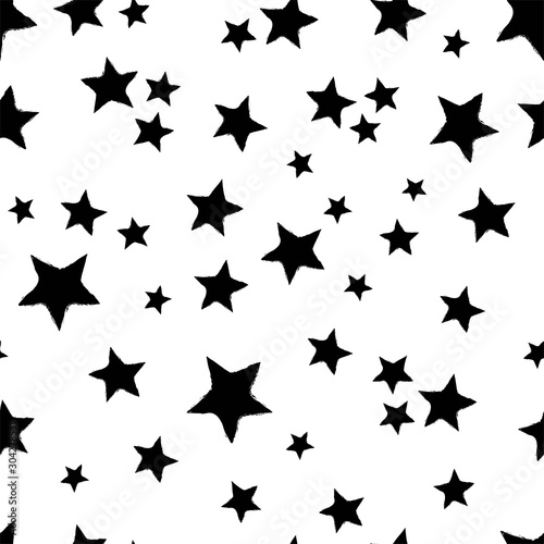 All over seamless repeat pattern with tossed black hand drawn sketched stars on a white background