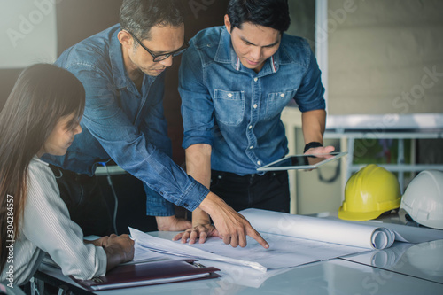 Architects,engineer holding pen pointing equipment architects On the desk with a blueprint in the office.Architect design concept.