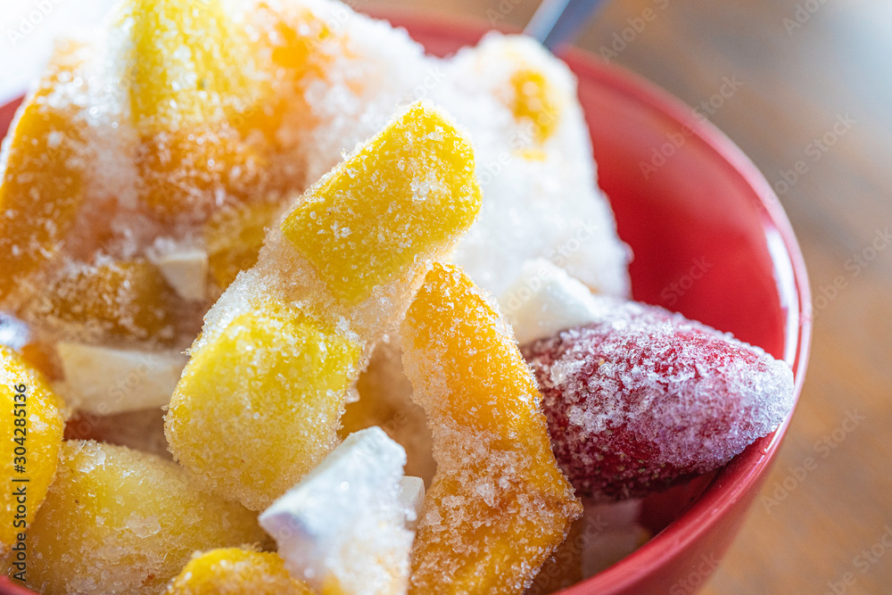 Frozen pieces of fruit in a red bowl to prepare smoothies Frozen pieces of fruit in a red bowl to prepare smoothies