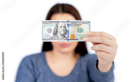 Woman holds banknote in hand, shallow depth of field, isolated on white background. Front view. Counting or spend money.