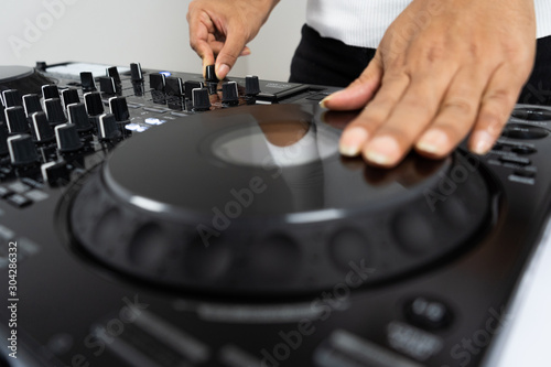 Hands of DJ mixing tracks on professional Dj Mixer