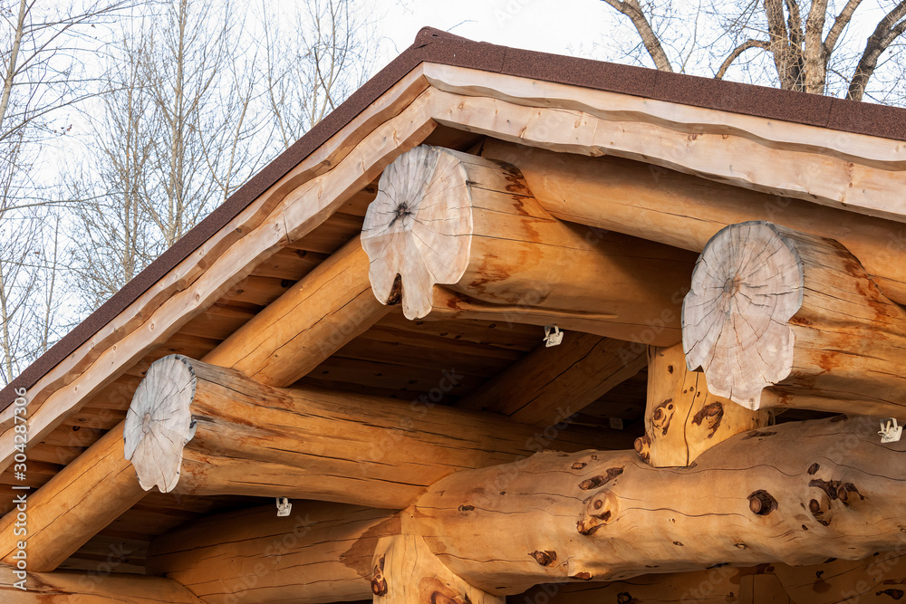 Wooden roof mounted on huge trunks of solid pine, wooden columns Wooden roof mounted on huge trunks of solid pine, wooden columns