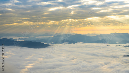 Misty mountains panorama in the morning with crepuscular sun rays during sunrise time, Phu Chi Dao Chiangrai Thailand