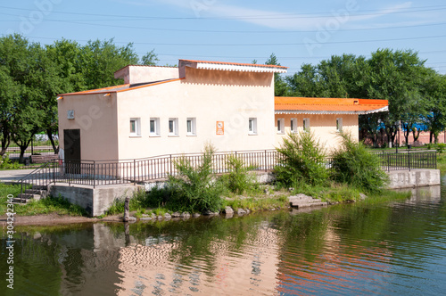Russia, Blagoveshchensk, July 2019: orange building on a pond in friendship Park in Blagoveshchensk in summer