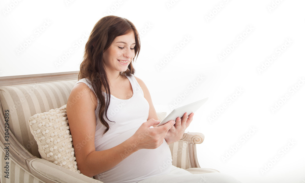 Smiling female using digital pad during pregnancy