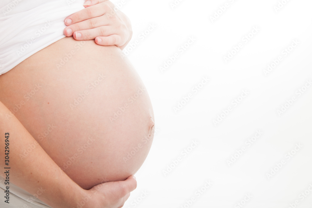 Profile view of pregnant belly on white background