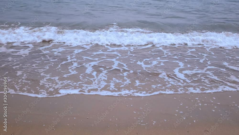 Surf over sand beach. Sea waves rolling gently up on sandy beach. Surf over sand beach. Sea waves rolling gently up on sandy beach.