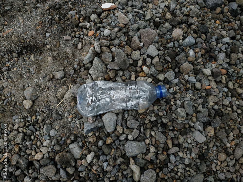 Plastic bottle in forest with gravel on the background Plastic bottle in forest with gravel on the background