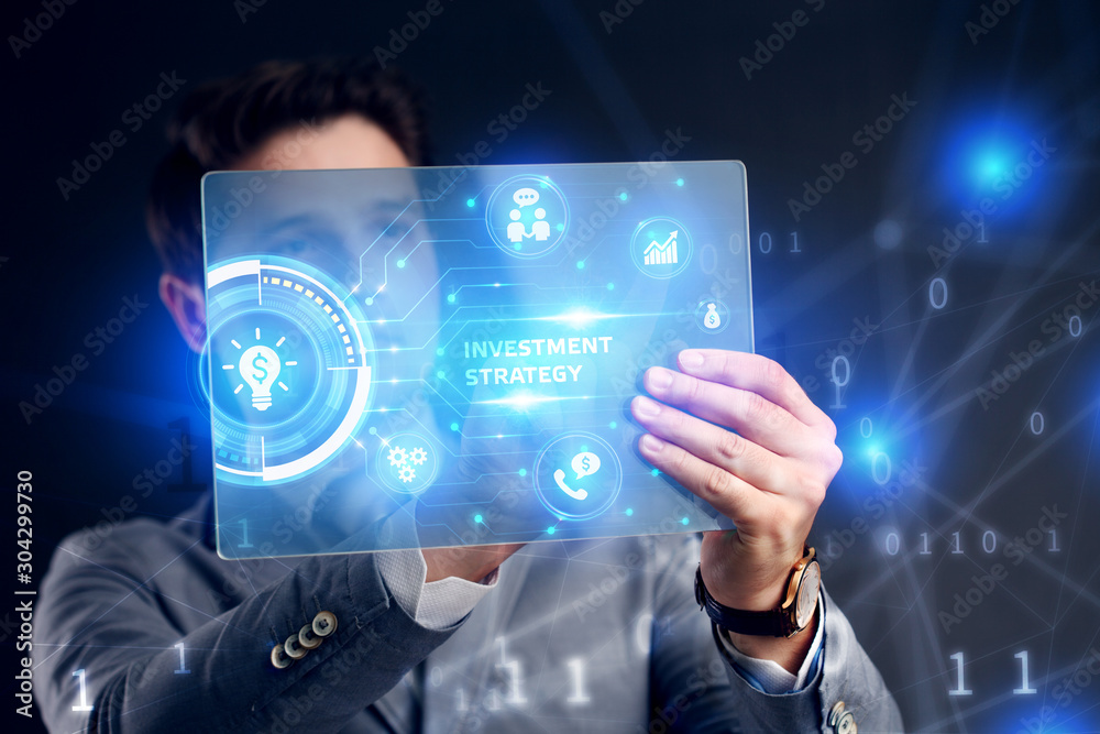 Planning marketing strategy. Business, Technology, Internet and network concept. Businessman working on the tablet of the future, select on the virtual display: Investment strategy Planning marketing strategy. Business, Technology, Internet and network concept. Businessman working on the tablet of the future, select on the virtual display: Investment strategy