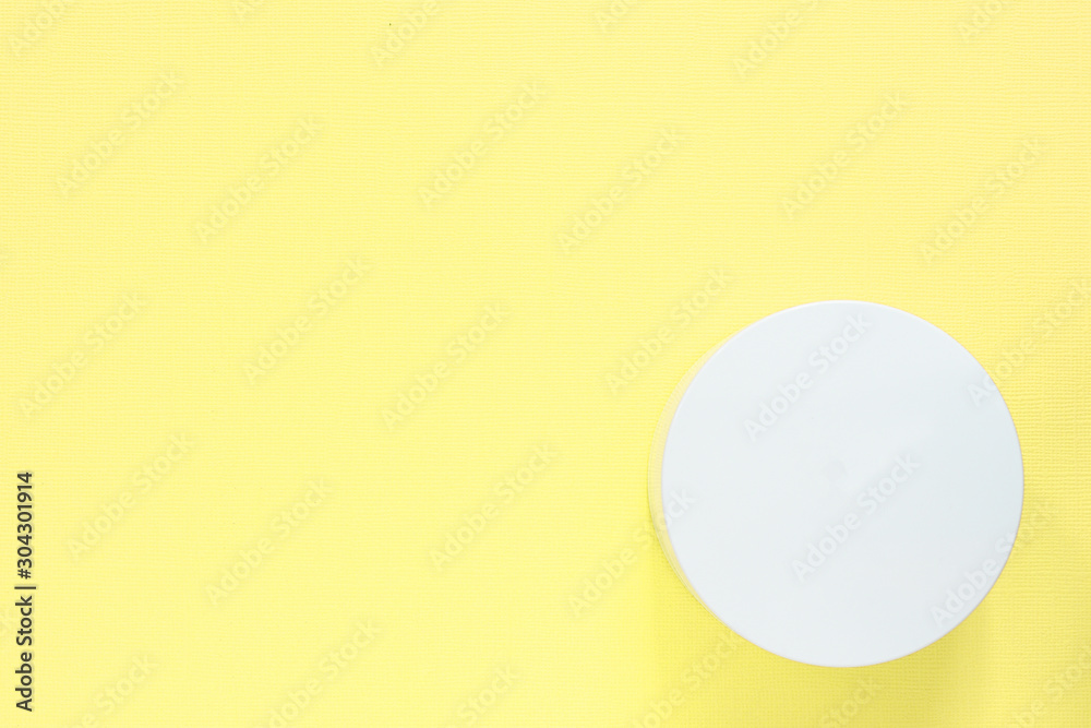 Cosmetic jar on a yellow background. Health and beauty. Top view, copy space Cosmetic jar on a yellow background. Health and beauty. Top view, copy space