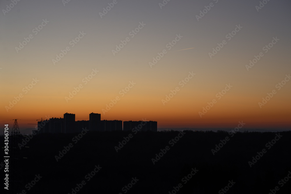 Dawn on the background of houses. Uniform background for the inscription. Modern residential complex early in the morning