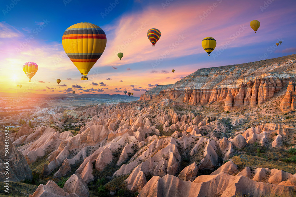 Hot air balloons and Red valley  at sunset in Goreme, Cappadocia in Turkey.