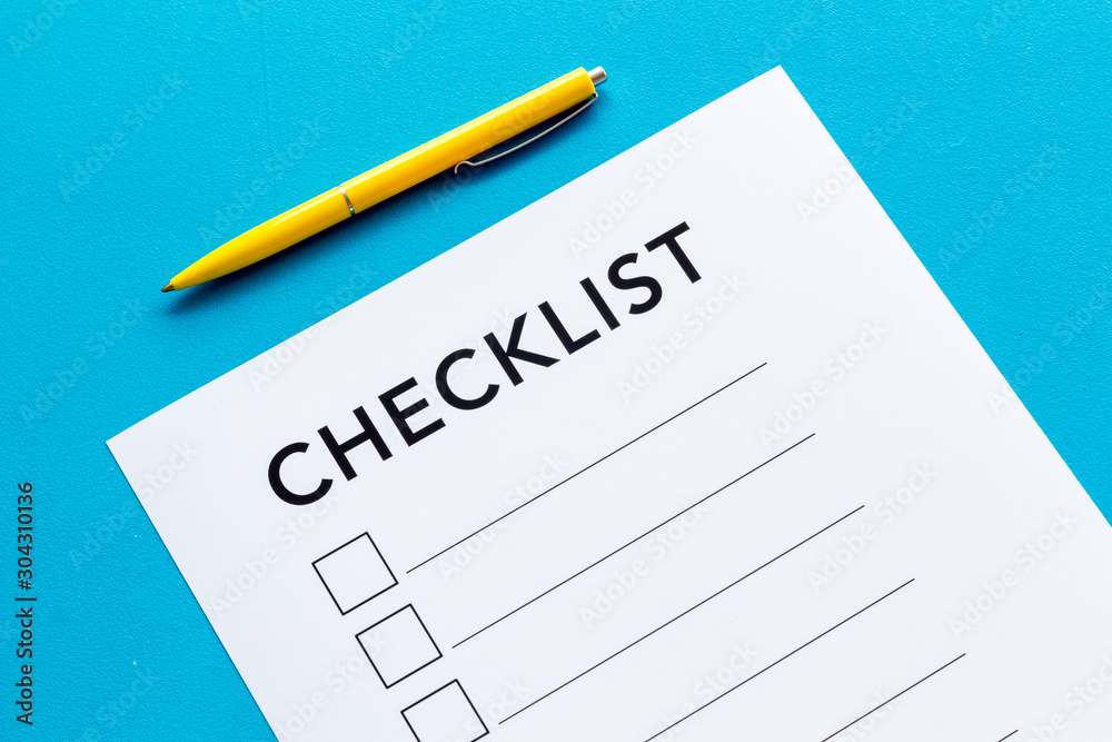 Checklist close up and pen on blue background top view Checklist close up and pen on blue background top view