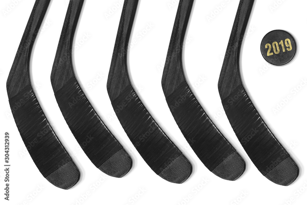 Five hockey sticks and puck on ice Five hockey sticks and puck on ice