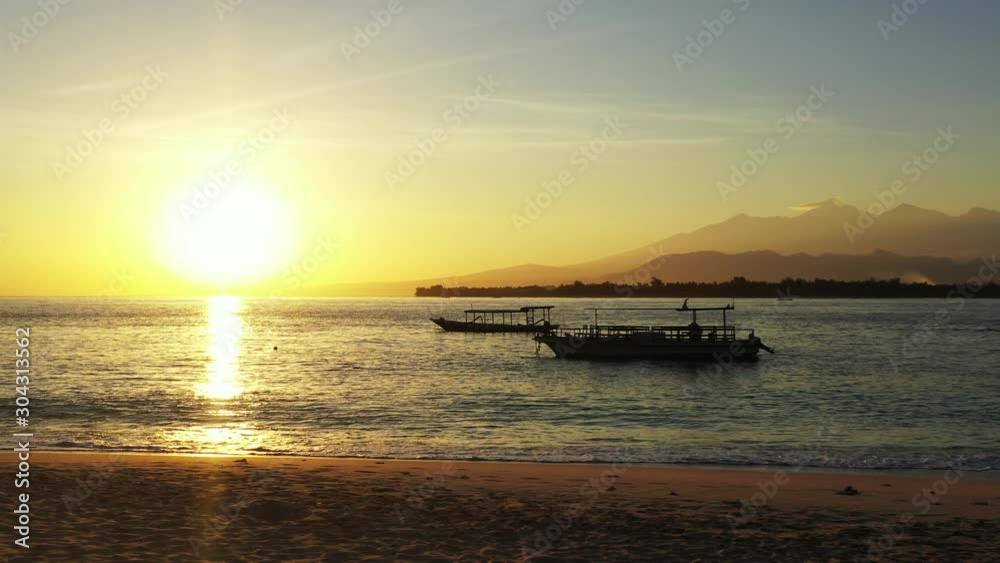 Kokomo Resort In Gili Gede, Indonesia - Silhouette Two Boats Slowly Sailing Across The Sea During Golden Hours - Wide Shot Kokomo Resort In Gili Gede, Indonesia - Silhouette Two Boats Slowly Sailing Across The Sea During Golden Hours - Wide Shot