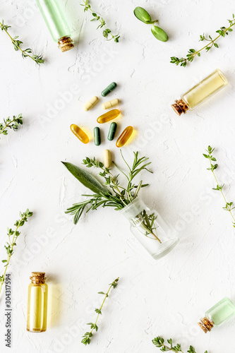 Medicine made from wildflowers and herbs with essential oils on dark wooden background top view pattern