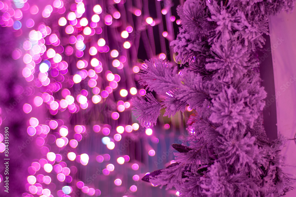 Lightly blurred pink Christmas background with fir branch and holiday lights. Lightly blurred pink Christmas background with fir branch and holiday lights.