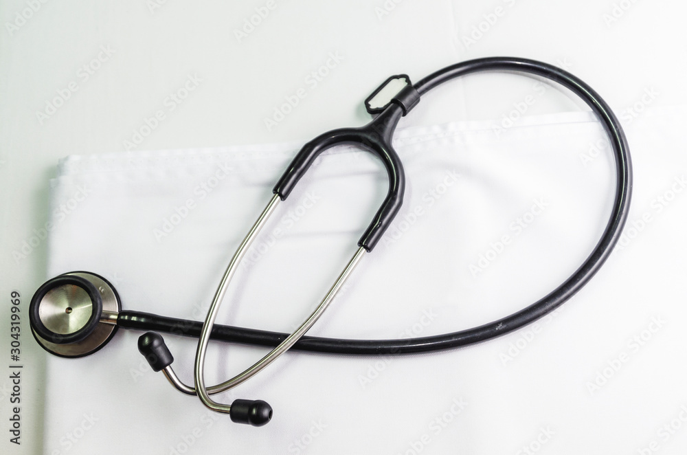 Medical stethoscope put on a white cloth on the table Medical stethoscope put on a white cloth on the table
