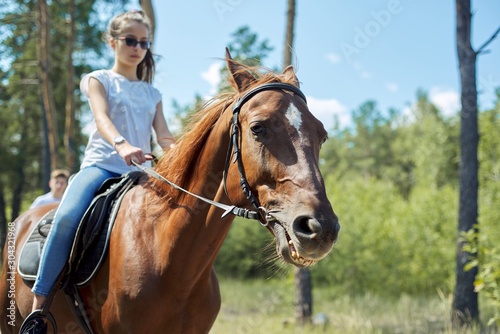 Close up of brown horse running with teenage rider girl © Valerii Honcharuk