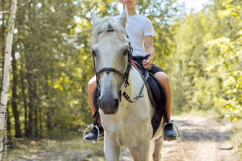 Close up of white horse running with teenage rider boy © Valerii Honcharuk