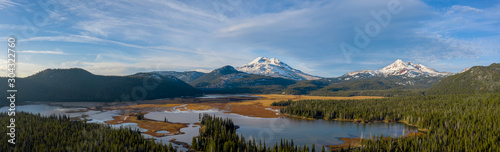Aerial panorama view of picturesque northwest natural landscape with beautiful snowcapped mountains in distance past tranquil lake © Gabe Shakour