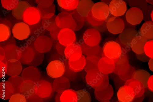 Abstract festive blurred background of bright red lights. Christmas, New Year, romance concept. Garland lights in beautiful bokeh.