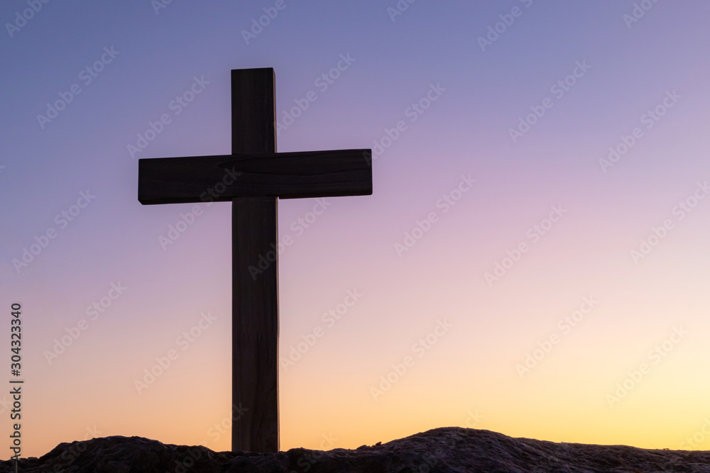 cross crucifixion of the crucifixion of jesus christ on a mountain with a sunset sky background