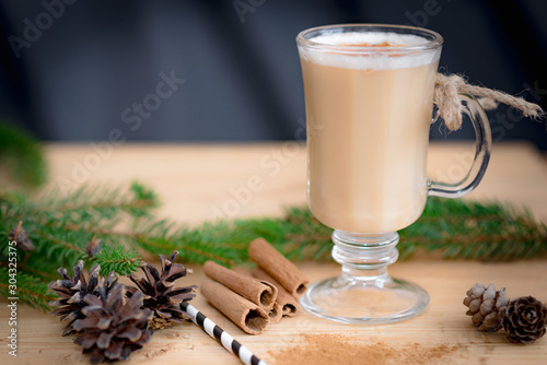 Chocolate Martini Cocktail or eggnog with cinnamon and chocolate in glass for Christmas on mahogany background. Homemade festive cocktail for winter holidays.Close up.