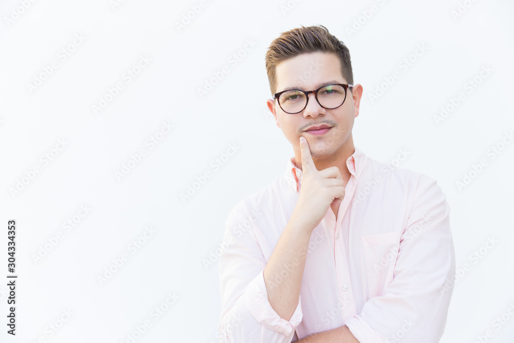 Pensive professional thinking over solution. Young man in glasses standing isolated over white background. Decision making concept Pensive professional thinking over solution. Young man in glasses standing isolated over white background. Decision making concept