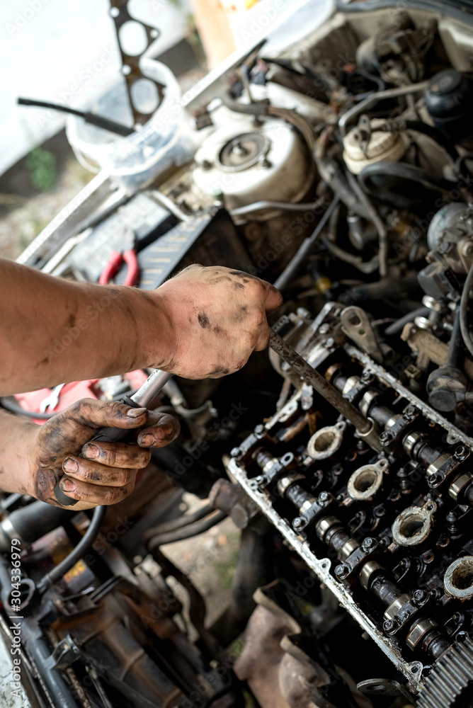 Obraz premium A man does a broach of the head. Makes car repair, engine malfunctioning