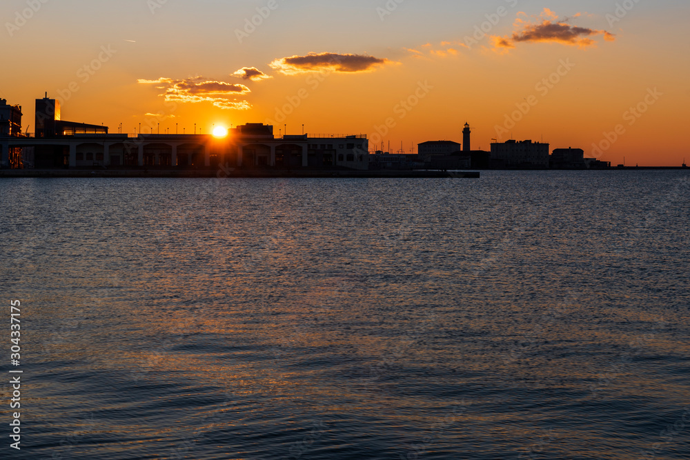 Sunset from the Audace pier of Trieste. Colors of fire on the water. Italy