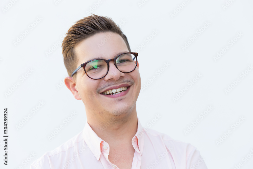 Closeup of happy joyful guy in eyeglasses laughing and looking at camera. Young man in glasses standing isolated over white background. Human emotions concept