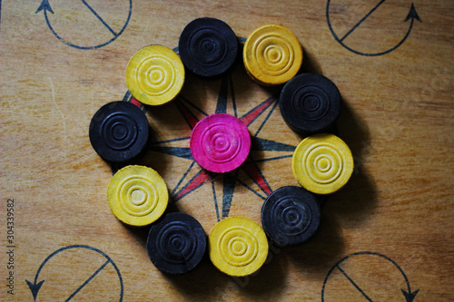 A game of carom set and ready to play.A game of carrom with pieces carrom man on the board carrom.Carom board game, selective focus.